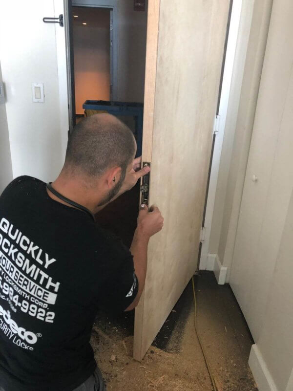 Our locksmith technician installing a brand new door in a residential building in Miami FL
