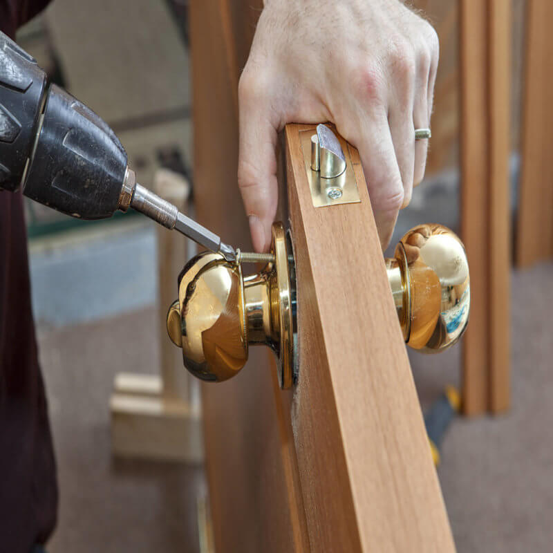 locksmith technician prepares the door for installation at a condo in Miami FL