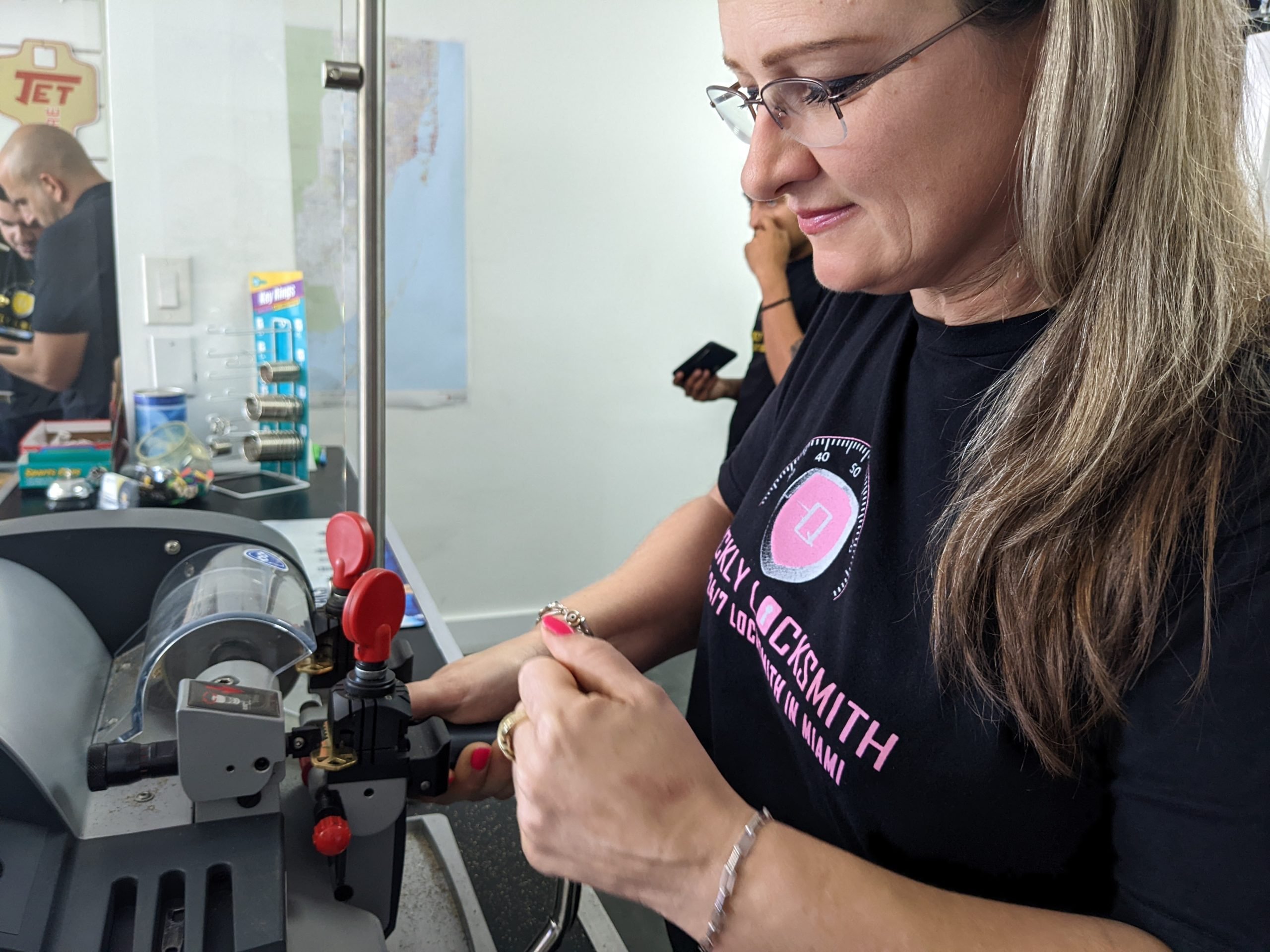 Quickly Locksmith Miami technician cutting a new key using precision key duplication equipment inside the locksmith shop